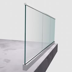 a glass window sitting on top of a cement wall next to a concrete floor and white walls