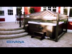 a hot tub sitting on top of a patio next to steps and a red building