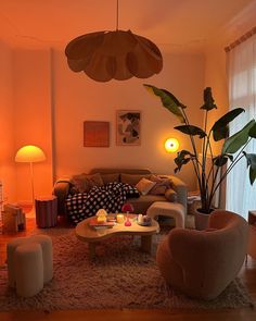 a living room filled with lots of furniture and plants in the middle of the room