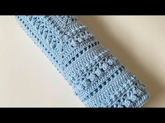 a blue crocheted pillow sitting on top of a white table