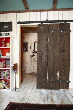 an open door is in the middle of a room with bookshelves and shelves