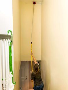 a man is cleaning the stairs with a mop and bucket in an apartment hallway