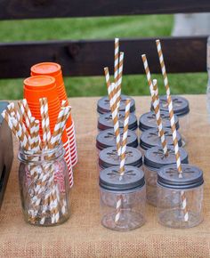 there are many mason jars with straws in them on the table next to each other