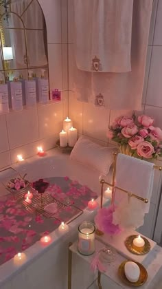 a bathtub with candles and flowers in it