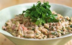 a white bowl filled with beans and parsley