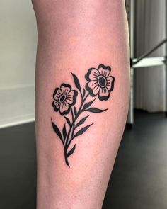 a black and white flower tattoo on the leg