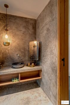 a bathroom with a sink, mirror and lights on the wall next to an open door