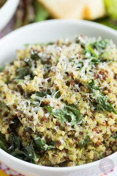 a close up of a bowl of food with spinach and cheese on top,