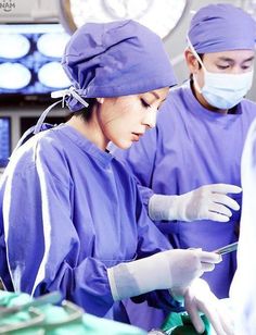 two surgeons are performing surgery in an operating room