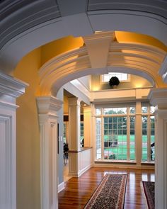 an archway leading into a living room with hard wood flooring and white trim on the walls