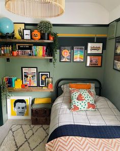 a bed room with a neatly made bed and lots of pictures on the wall above it