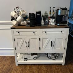 a kitchen island made out of cabinets with coffee pots and pans on the top