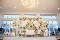 an elegant wedding setup with white flowers and chandelier