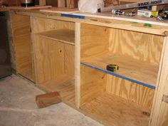 an unfinished kitchen counter being constructed with plywood