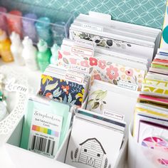 many cards are stacked in a box on the table next to some scissors and other crafting supplies