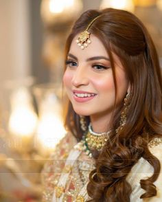 a woman with long brown hair wearing a gold head piece