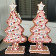 two decorated christmas trees sitting on top of a table