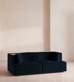 a blue couch sitting on top of a hard wood floor next to a white wall