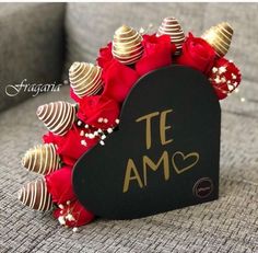 a bouquet of roses and chocolates in a heart shaped box with the word te amo written on it