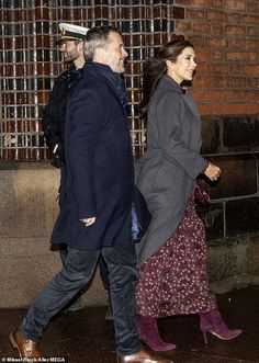 the man and woman are walking down the street in winter clothes, one is wearing purple boots