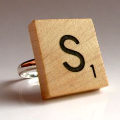 a small wooden block with the letter s on it's side and a ring in front of it