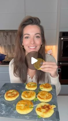 a woman is showing off some food in the kitchen