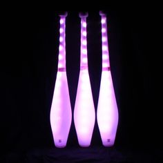 three lighted bowling pins sitting in the dark