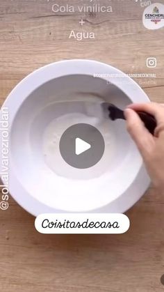 a person is painting a white bowl on a wooden table with words above it that read cola vinilica agua