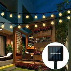 an outdoor patio with lights and plants on the outside, along with a solar powered string light