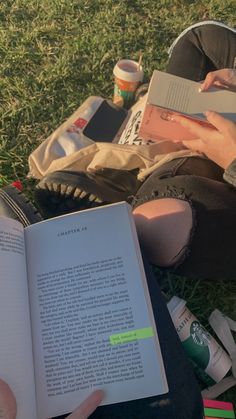 a person sitting on the grass reading a book