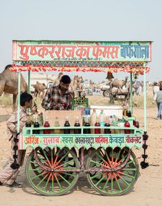 a man selling drinks from a cart in the desert