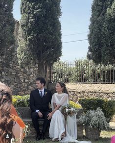 a man and woman sitting on a bench next to each other