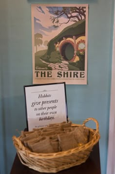 a basket sitting on top of a wooden table next to a sign that says the shire