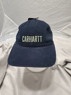 Add a touch of outdoor style to your wardrobe with this Carhartt Navy Blue Script Hat. Made from lightweight and breathable cotton canvas fabric, this baseball cap is perfect for travel, casual wear, or workwear. The adjustable strap ensures a comfortable fit for all sizes, while the solid blue color and script logos add a touch of vintage charm. Designed for men, this hat is perfect for outdoor enthusiasts who love to explore and enjoy the great outdoors. Made in Bangladesh, this Carhartt hat i Carhartt Baseball Hat, Carhartt Hat, Cotton Canvas Fabric, Money And Happiness, Script Logo, Outdoor Style, Great Outdoors, The Great Outdoors, Canvas Fabric