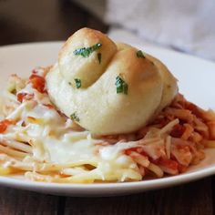 a white plate topped with pasta and rolls