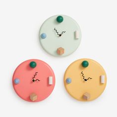 three different colored buttons with faces drawn on them