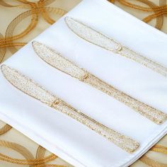 three pieces of white cloth with gold sequins on them