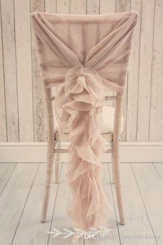 a chair with a pink ruffled sash on it