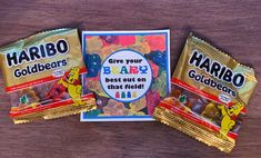 three bags of candy sitting on top of a wooden table next to an envelope with the words harbo goldbergs