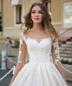 a woman in a white wedding dress posing for the camera with her hands on her hips