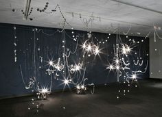 an empty room with lights hanging from the ceiling and stars on the wall above it