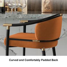 a black and gold chair sitting in front of a marble counter top with wine glasses on it