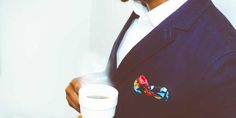 a man in a suit holding a cup of coffee