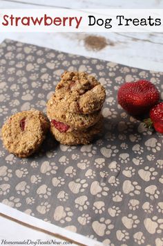 strawberries and cookies sitting on top of a table next to a dog paw print placemat