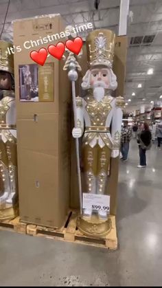 there are two large christmas statues on display in the store, one is gold and the other is white