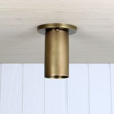 a close up of a light fixture on a wooden ceiling with white boards in the background