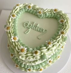 a heart shaped cake with daisies on it