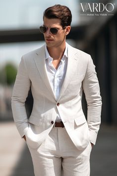 a man in a white suit and sunglasses