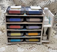 several plastic containers are stacked on top of each other in front of a crochet doily