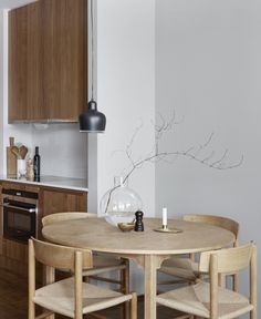 a wooden table with chairs around it in a small kitchen next to a stove and oven